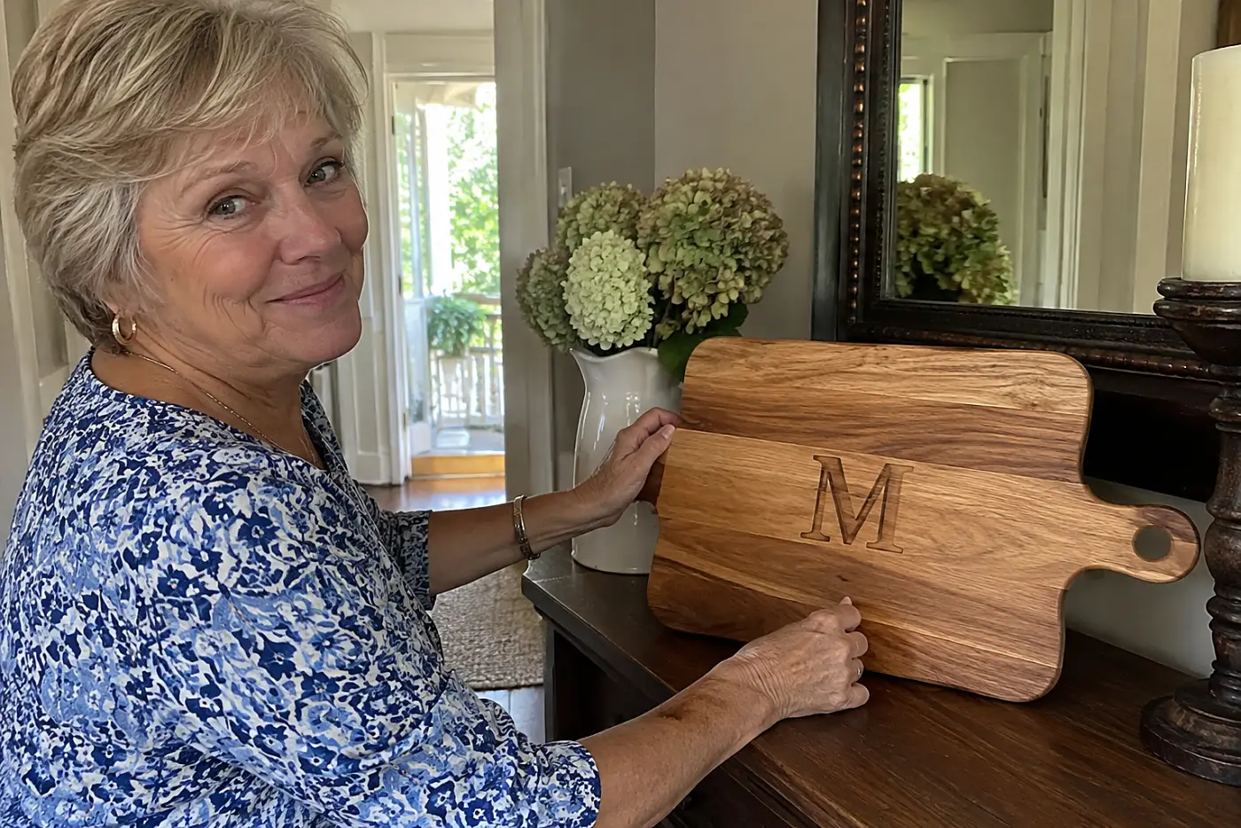 Woman in her sixties placing a personalized cutting board on a dining room sideboard.