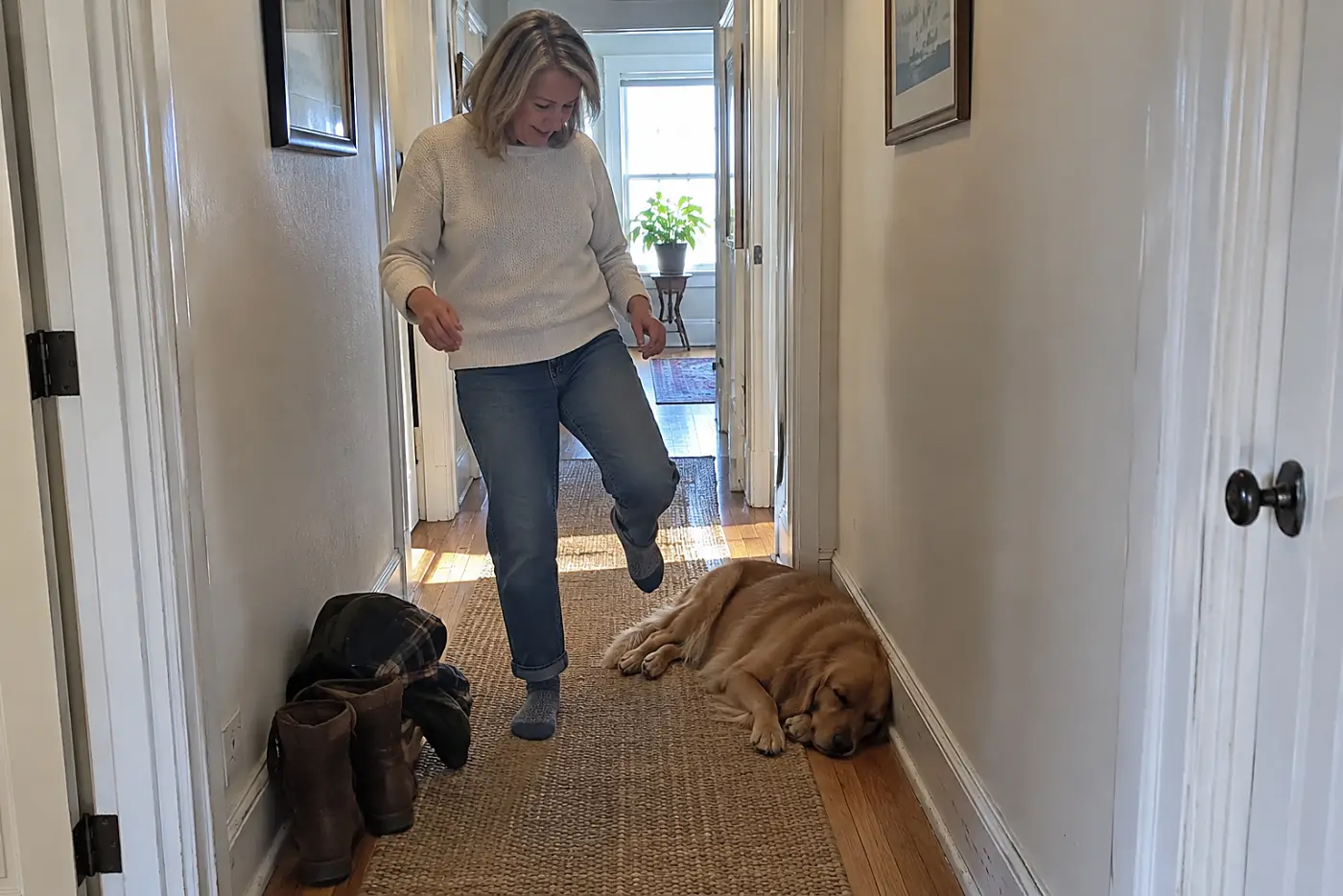 Woman in her sixties stepping around her sleeping dog in a hallway.
