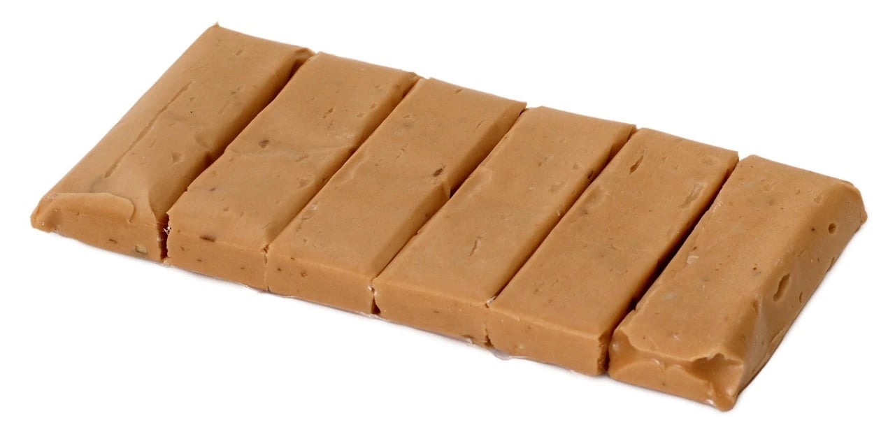 Flat light brown taffy bar divided into six pieces on a white background