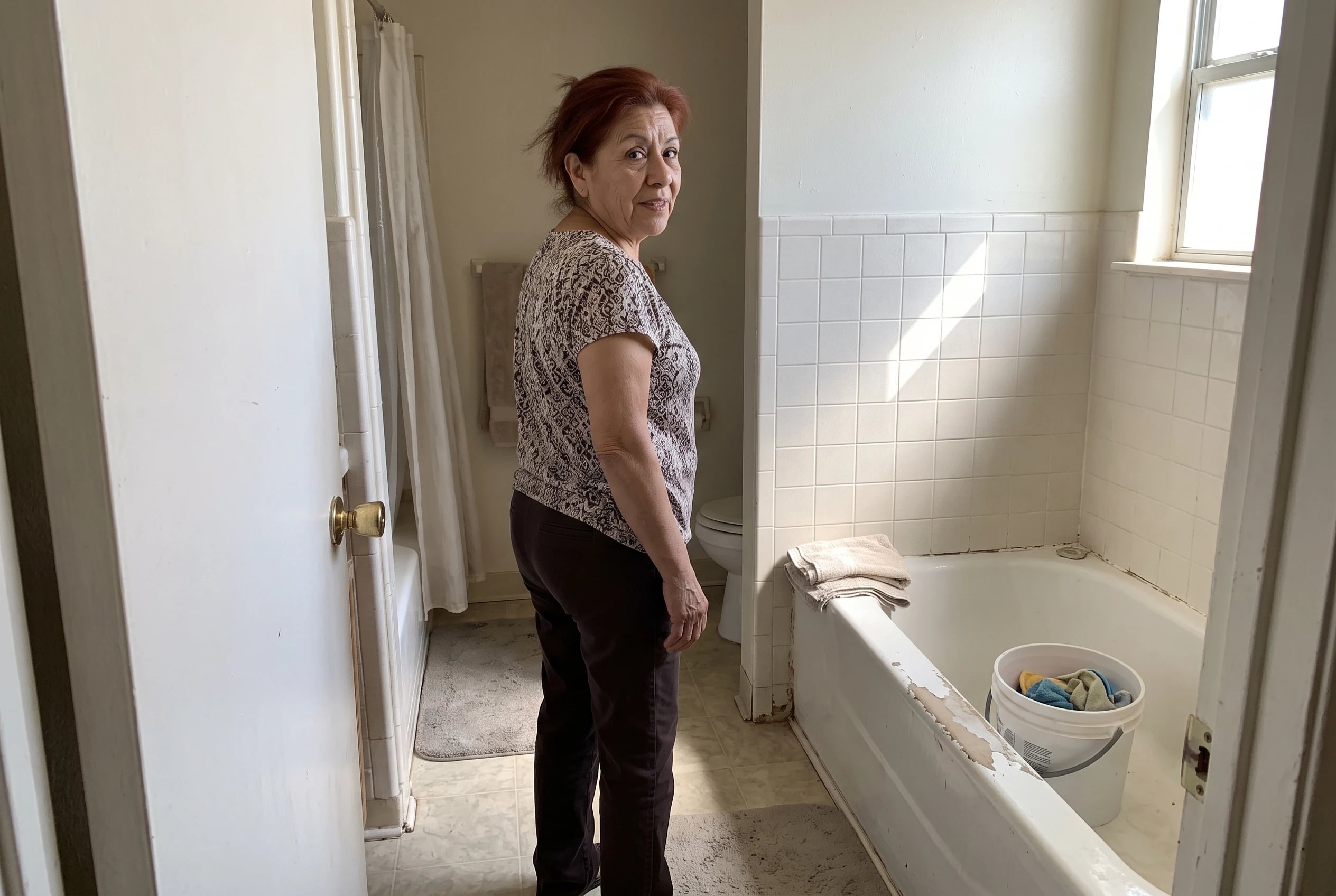 A woman walks through the main-floor bathroom of a house she is considering.