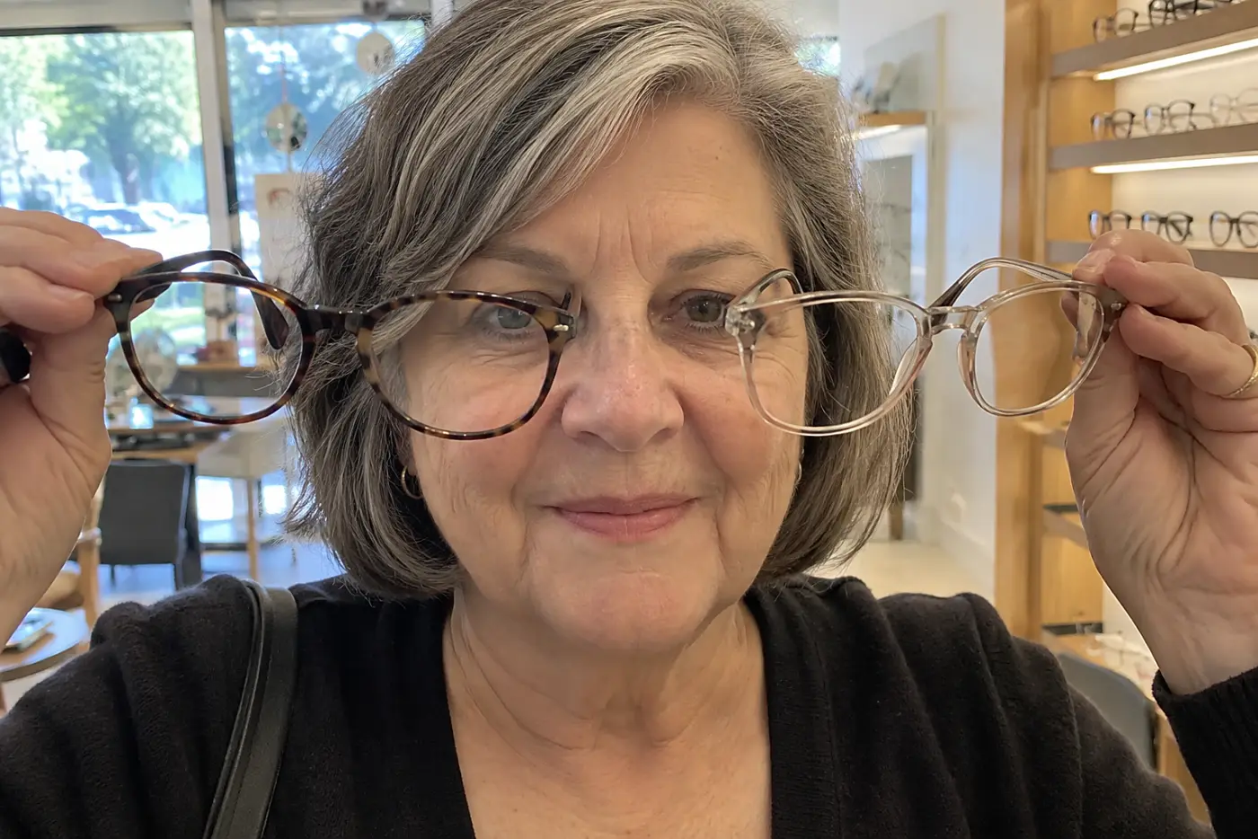 Woman laying her eyeglasses face down on a metal ruler in a sewing room.