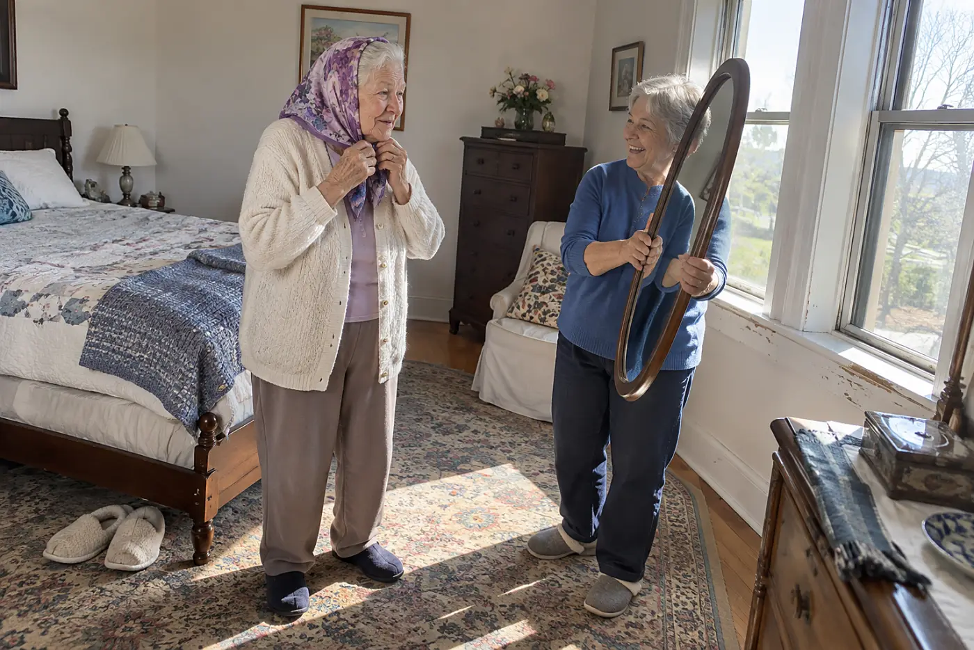 A woman in her seventies ties a violet print scarf while another holds a mirror.
