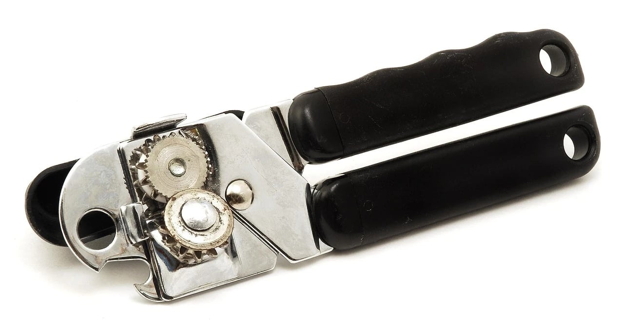 Manual can opener with black handles and chrome cutting wheel on a white background