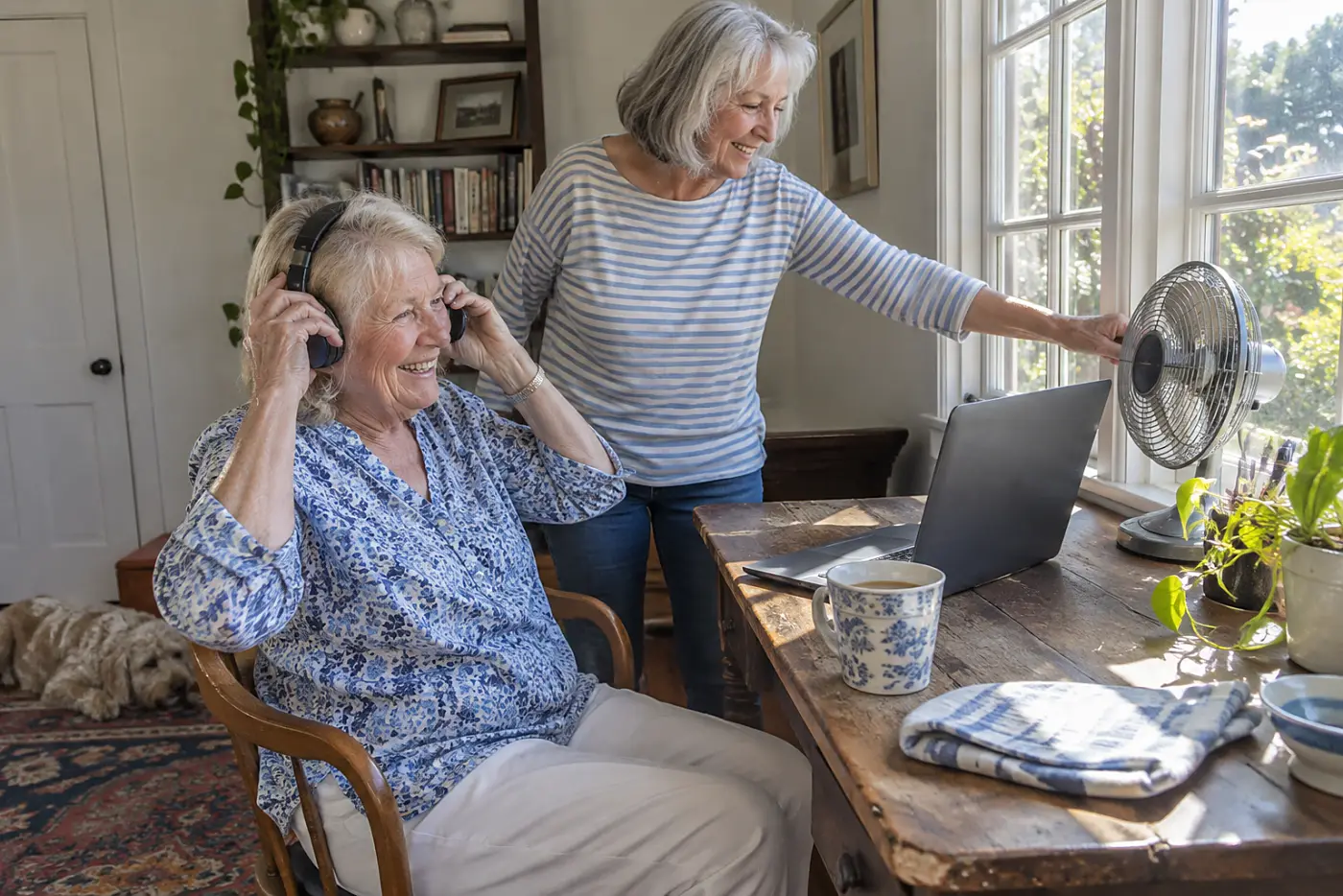 Grandmother putting on headphones before a call at her desk.