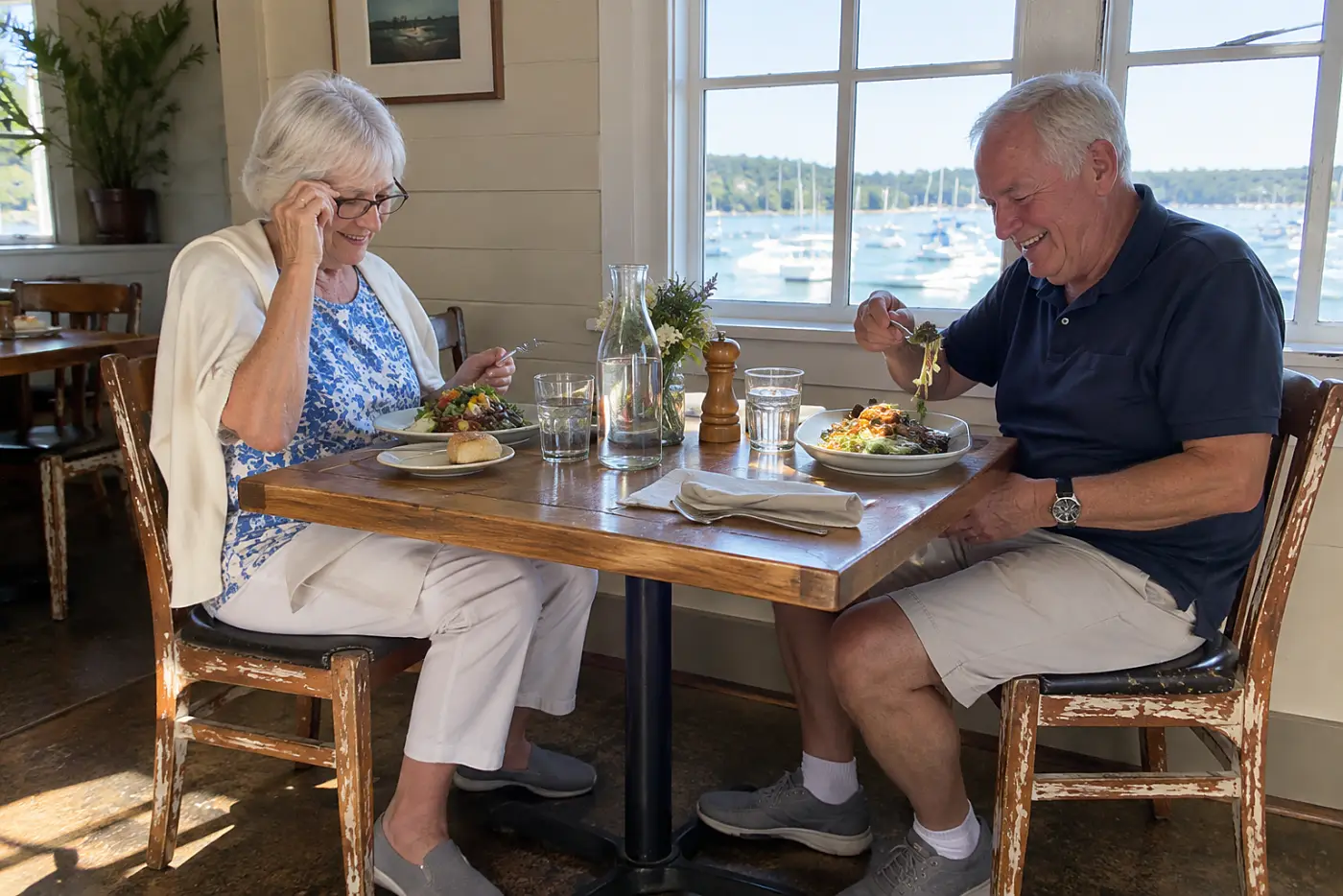 Older woman putting on reading glasses at a restaurant table.