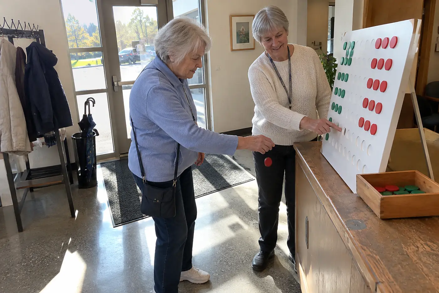 Older woman changing the name on a sign-in sheet at a community center.