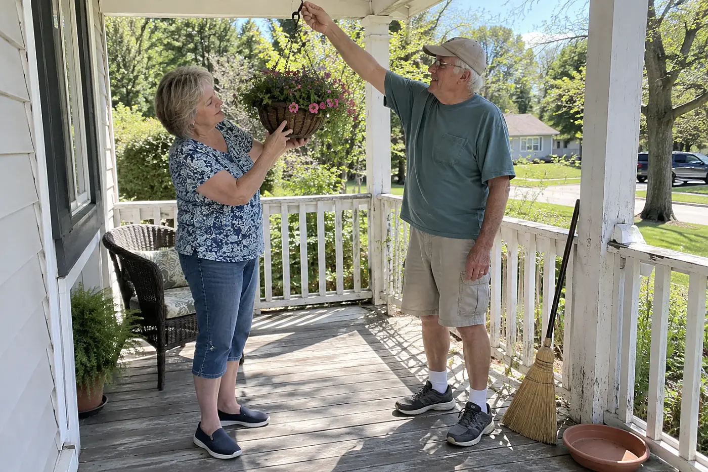 Woman holding a hanging basket at eye level to inspect its potting mix.