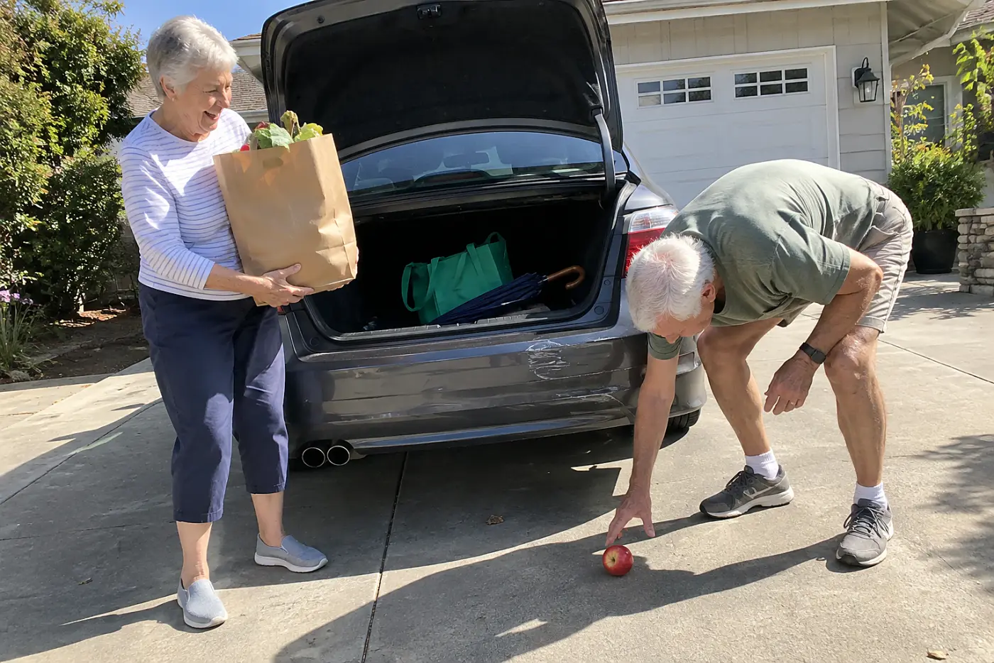 Older woman lifting a grocery bag from the trunk of her car.