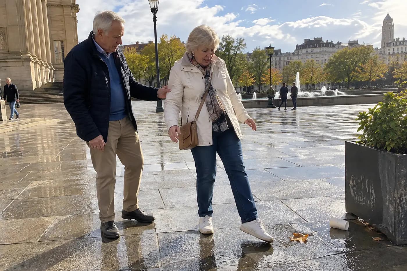 Woman testing wet paving with her shoe outside a plaza.
