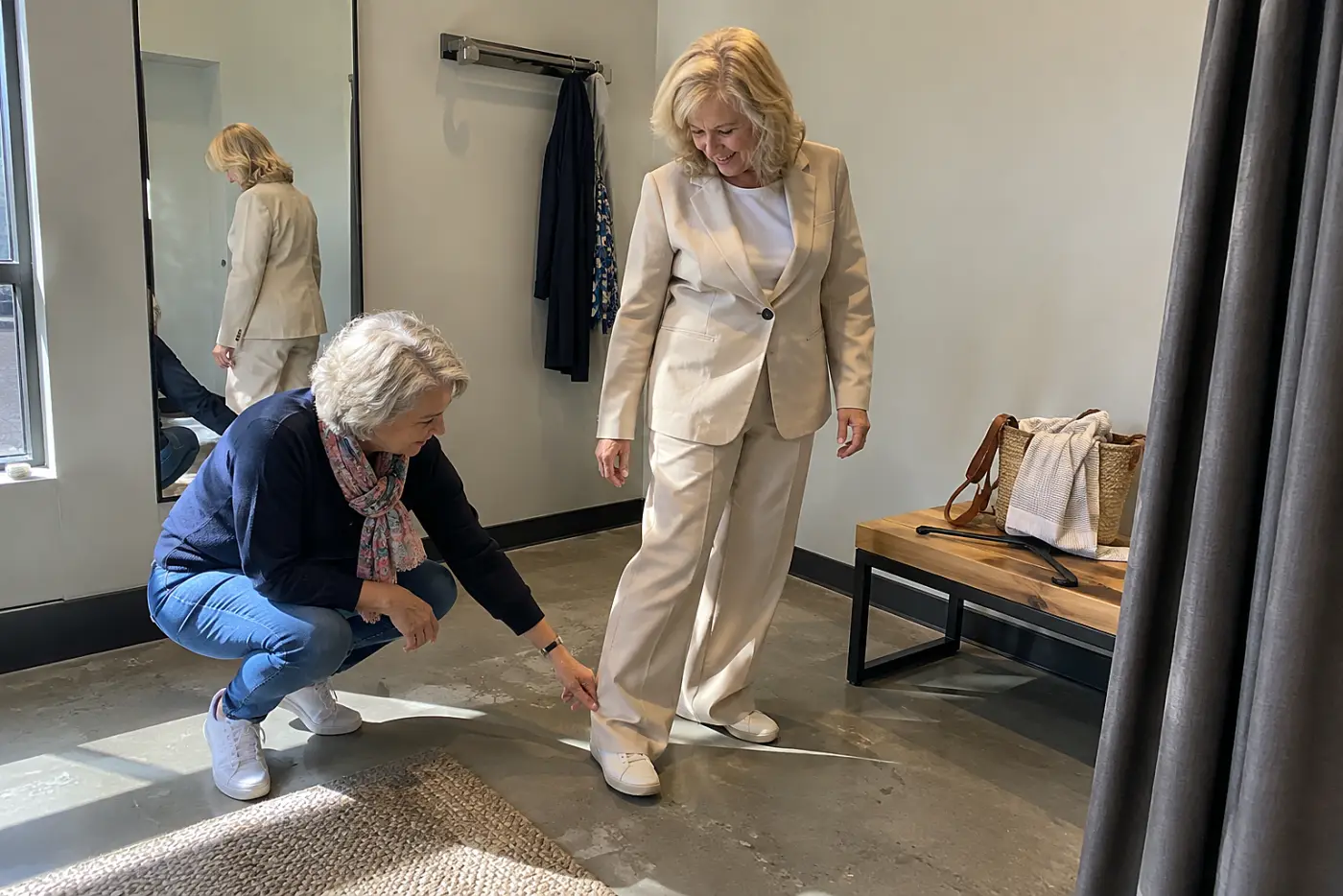 Older woman walking across a fitting room in a new outfit.