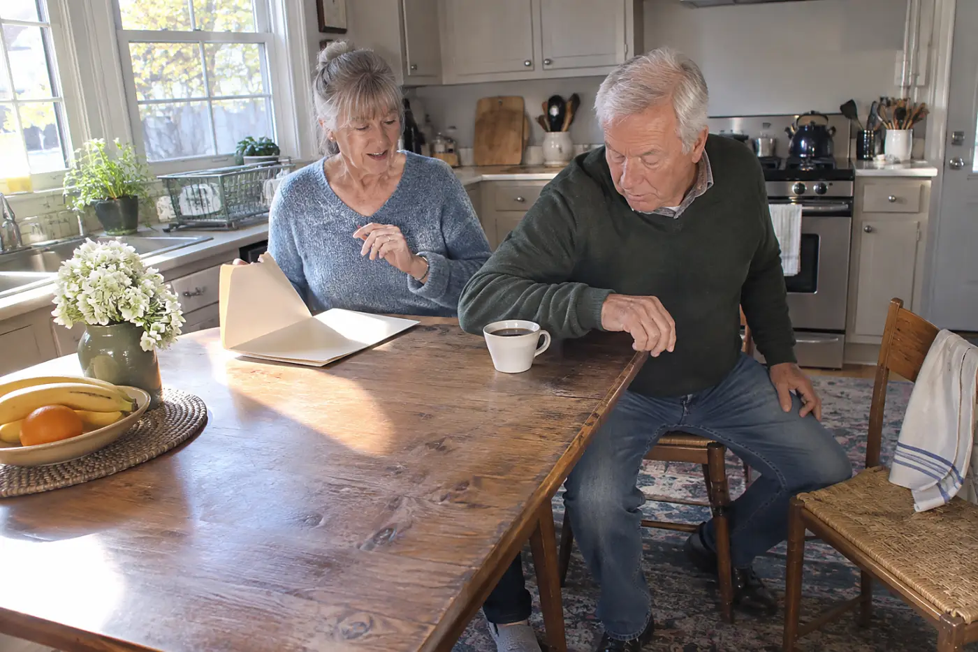 Older woman opening her homeowners policy beside a cup of coffee.