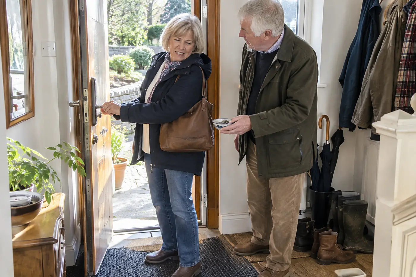 Older woman testing a spare key in her front door.