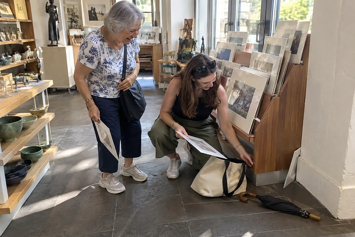 Grandmother and granddaughter looking at postcards in a gift shop.