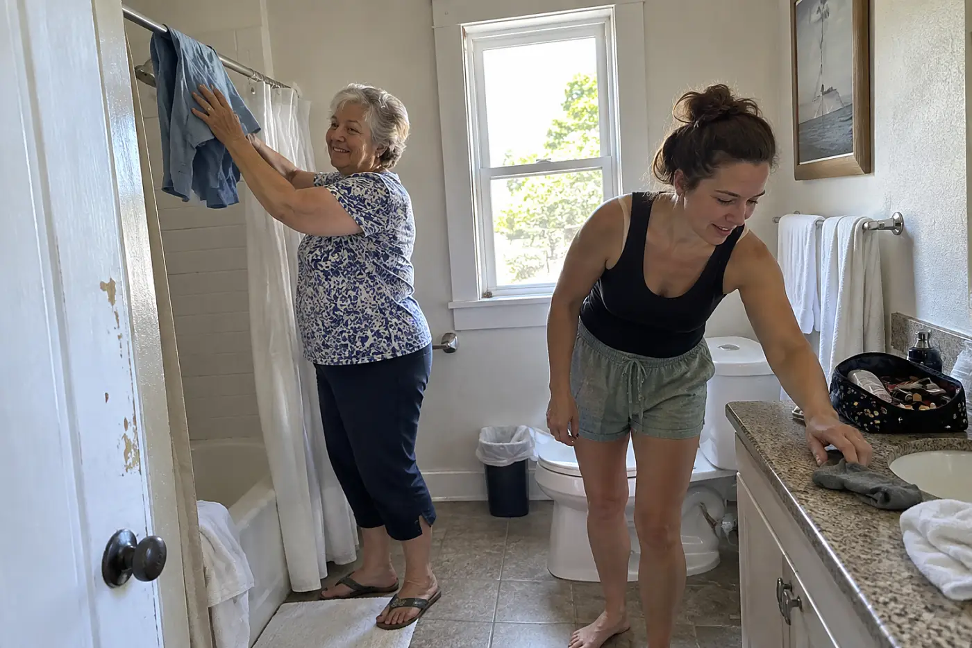 Grandmother hanging damp clothes in a hotel bathroom after dinner.