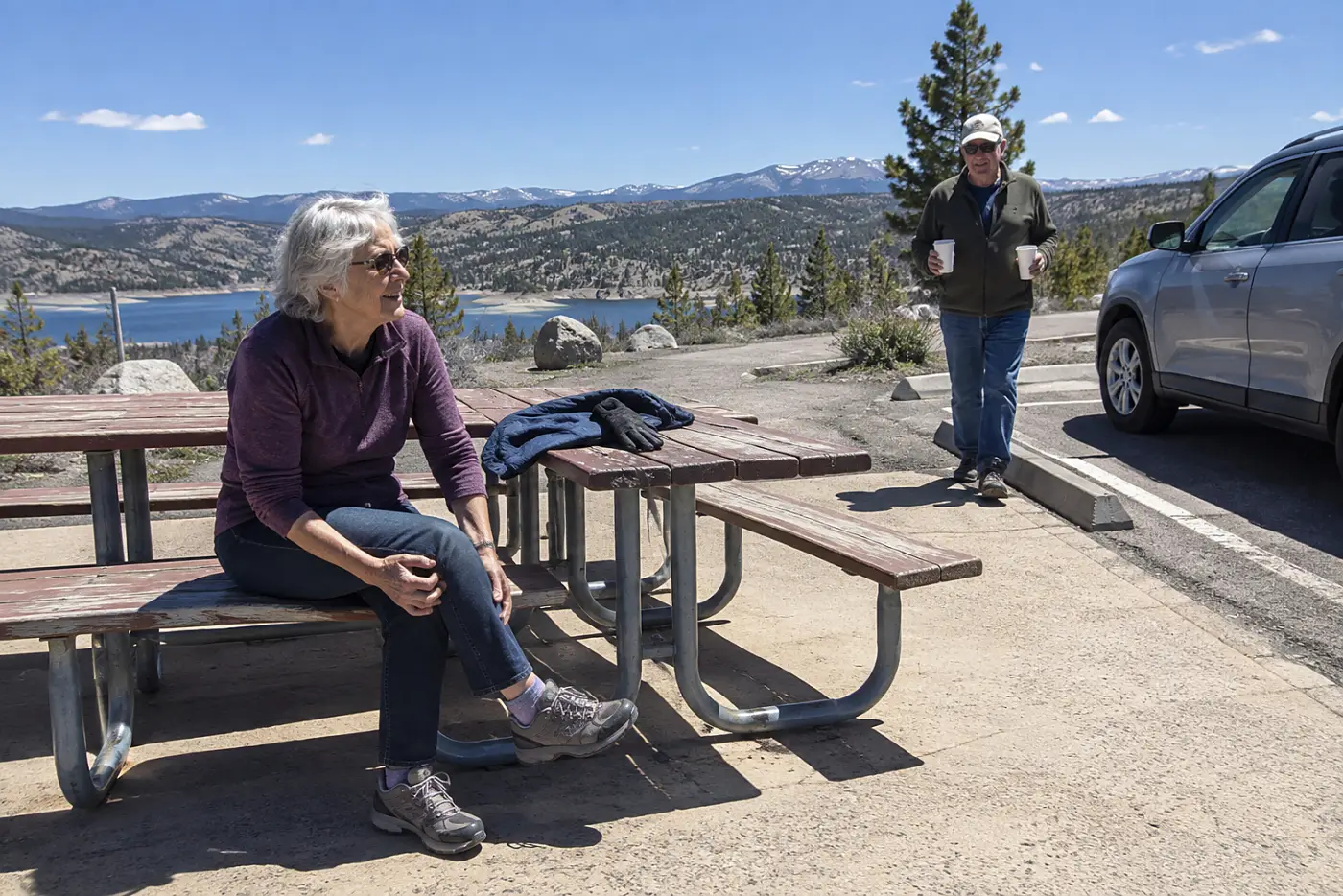 Older woman sitting at a roadside rest stop during a drive.