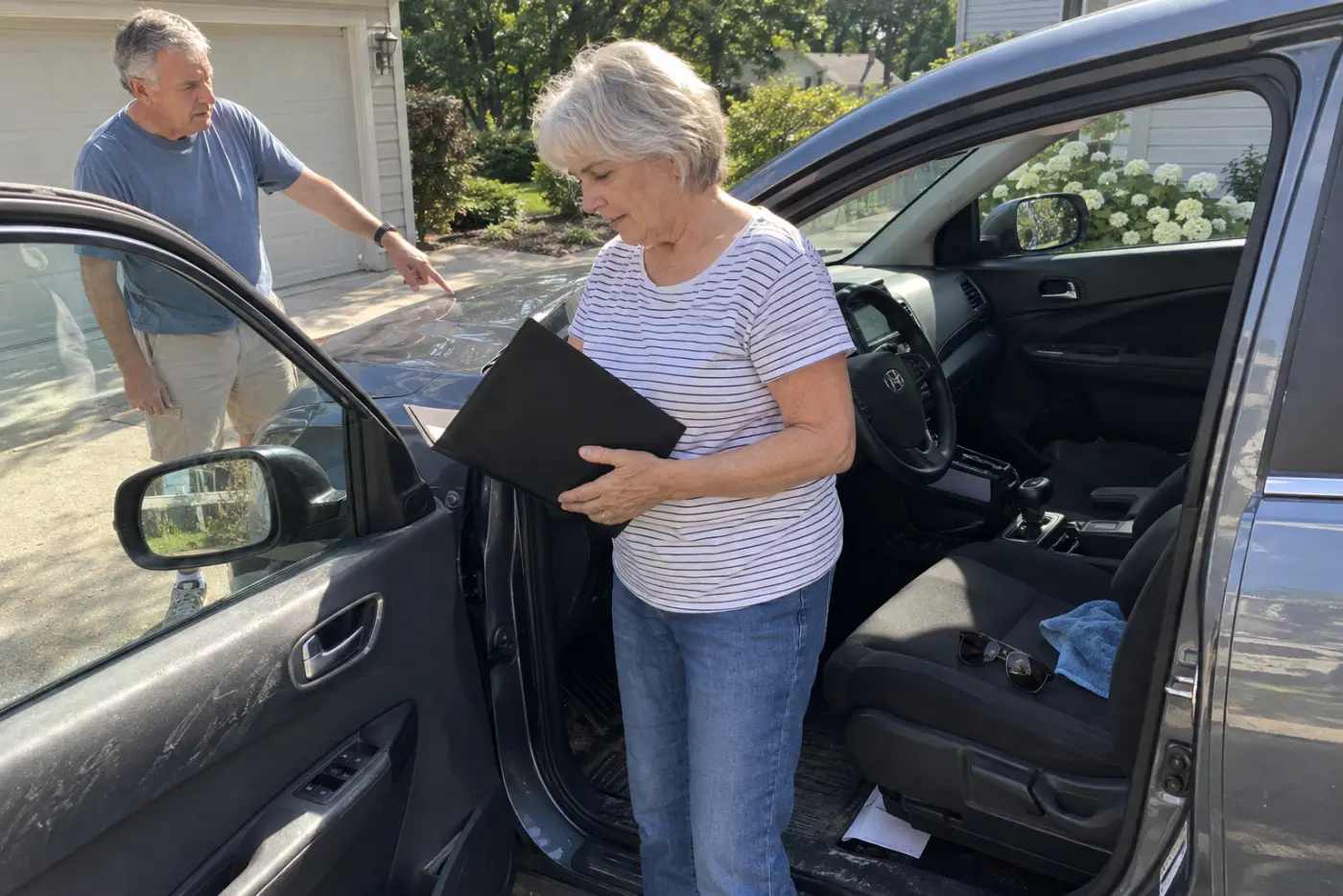 Older woman reading a repair estimate inside her parked car.