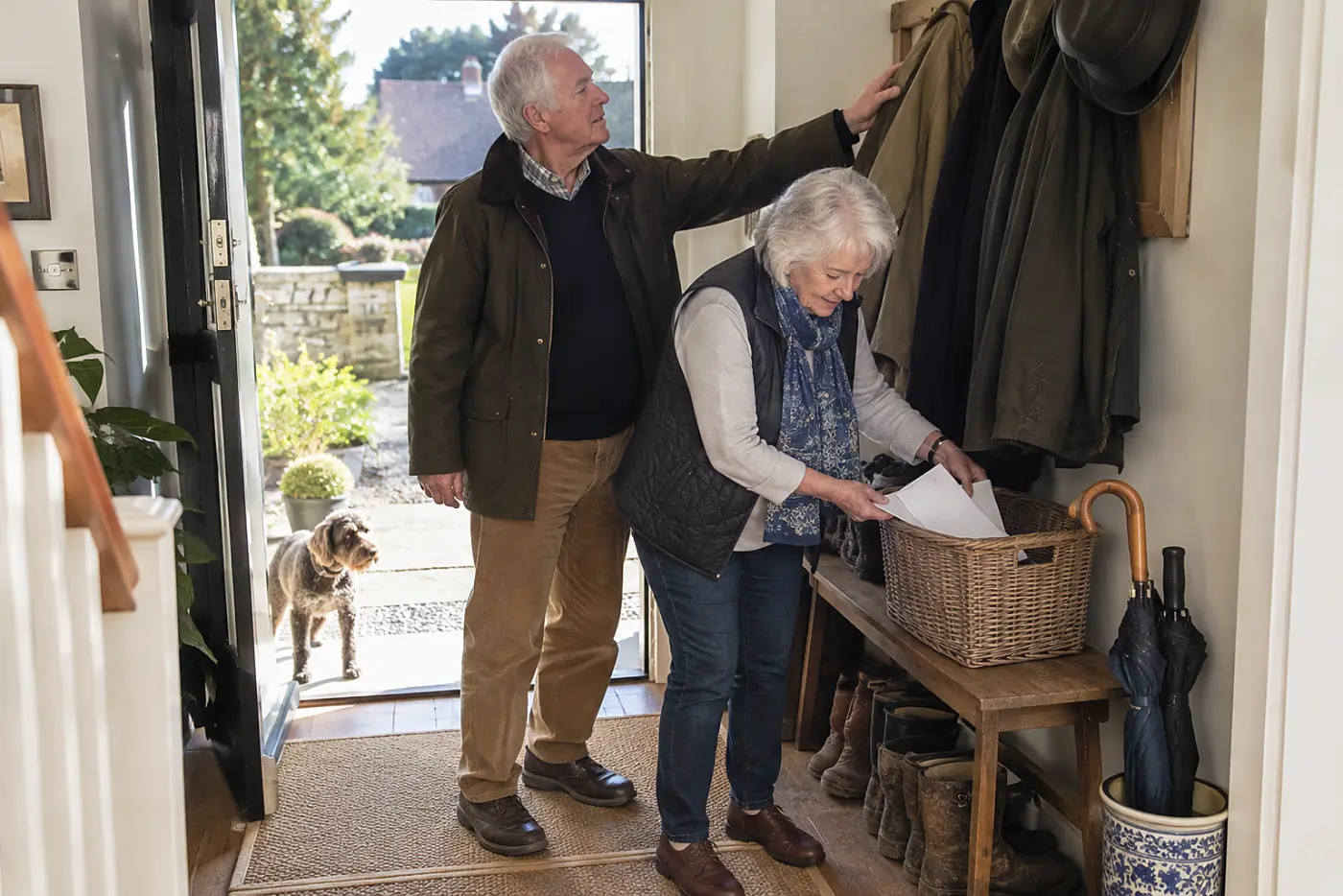 Older woman placing unopened letters in a basket by the front door.