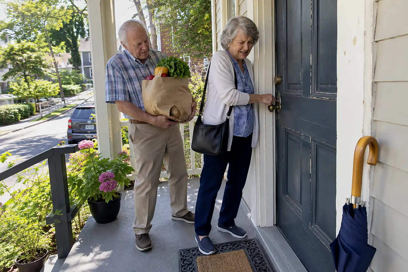 Older woman testing a key in her front door lock.