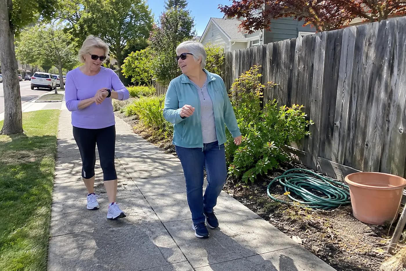 Older woman checking her watch during a walk on a familiar block.