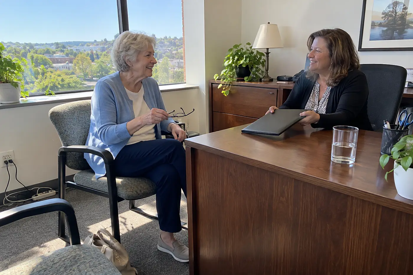 Woman speaking with an employee benefits representative in an office.