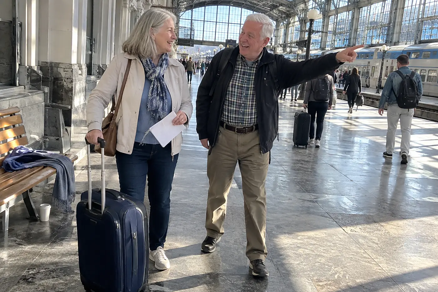 Older woman studying a station map beside her suitcase in a train terminal.