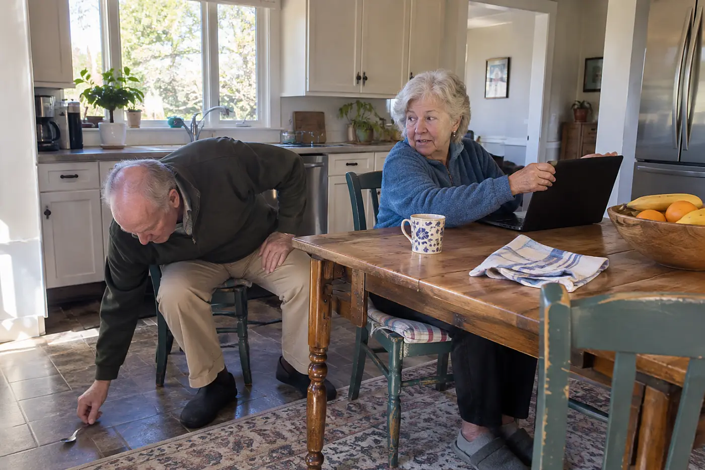 Older woman checking a Social Security deposit on her laptop at the kitchen table.