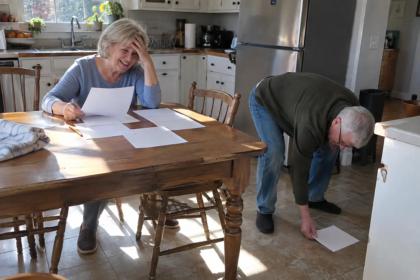 Older woman comparing bank transactions with utility bills at home.