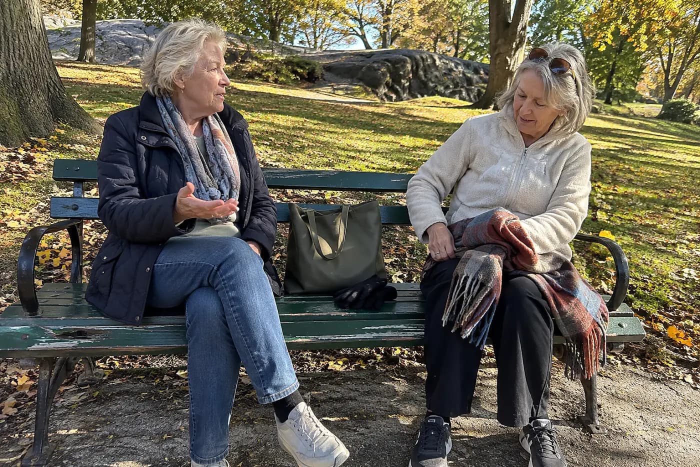 Two women talking on a park bench.