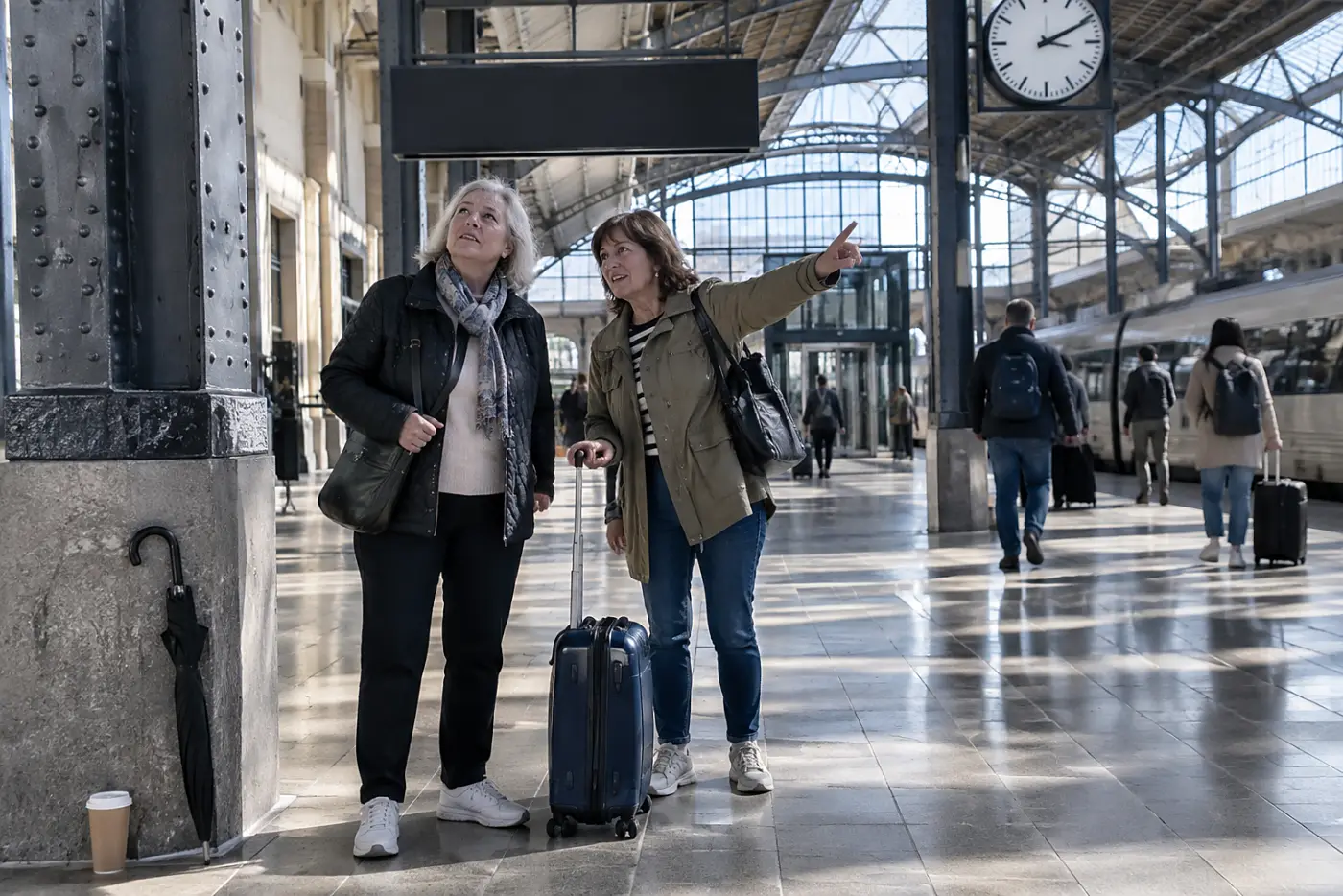 Woman checking a platform display beneath the station clock.