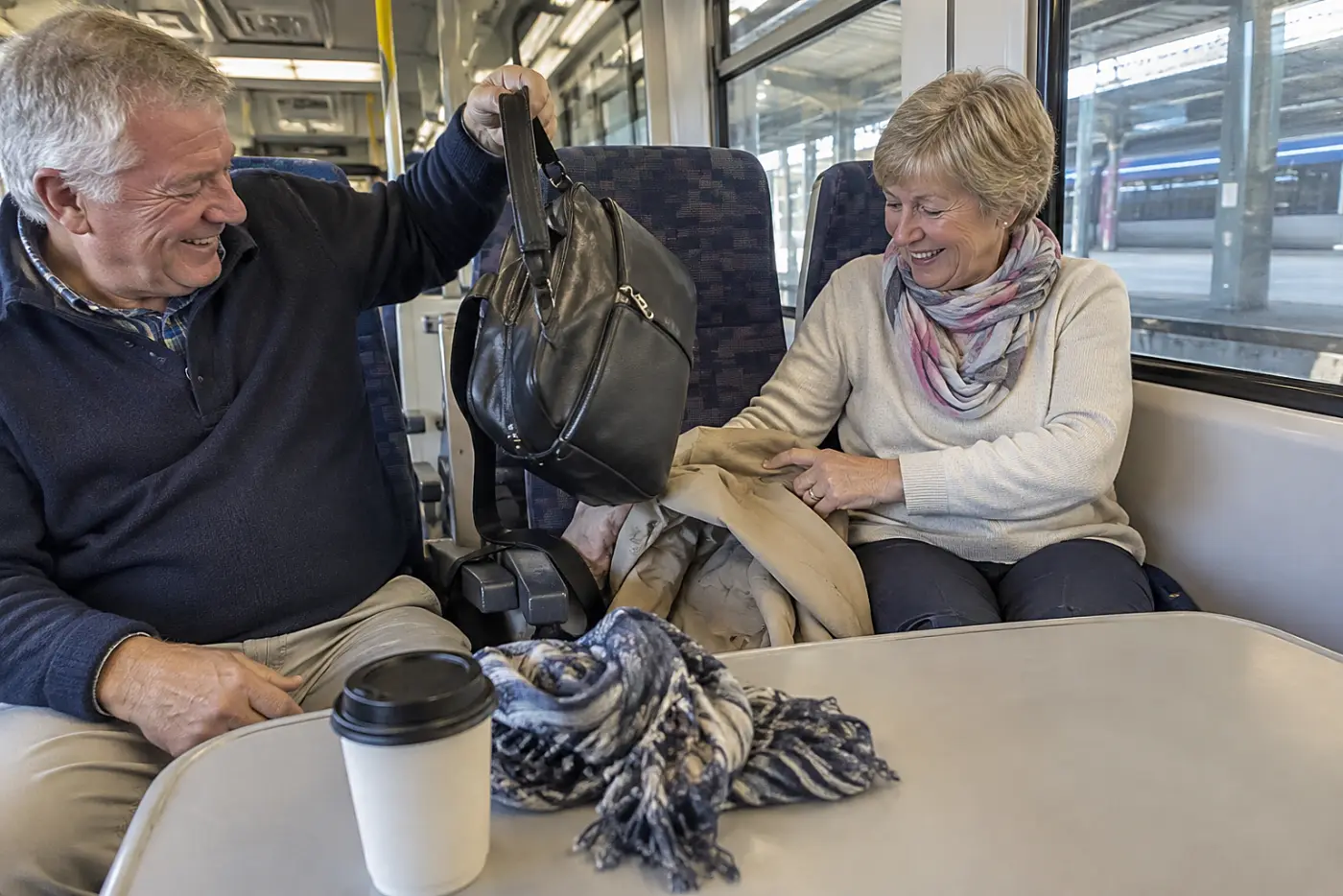 Woman collecting her coat as a train approaches her station.