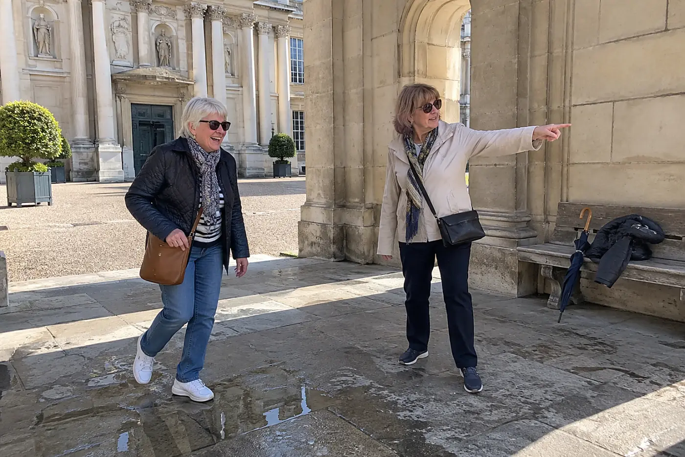 Two older women agreeing on a meeting place outside a museum.