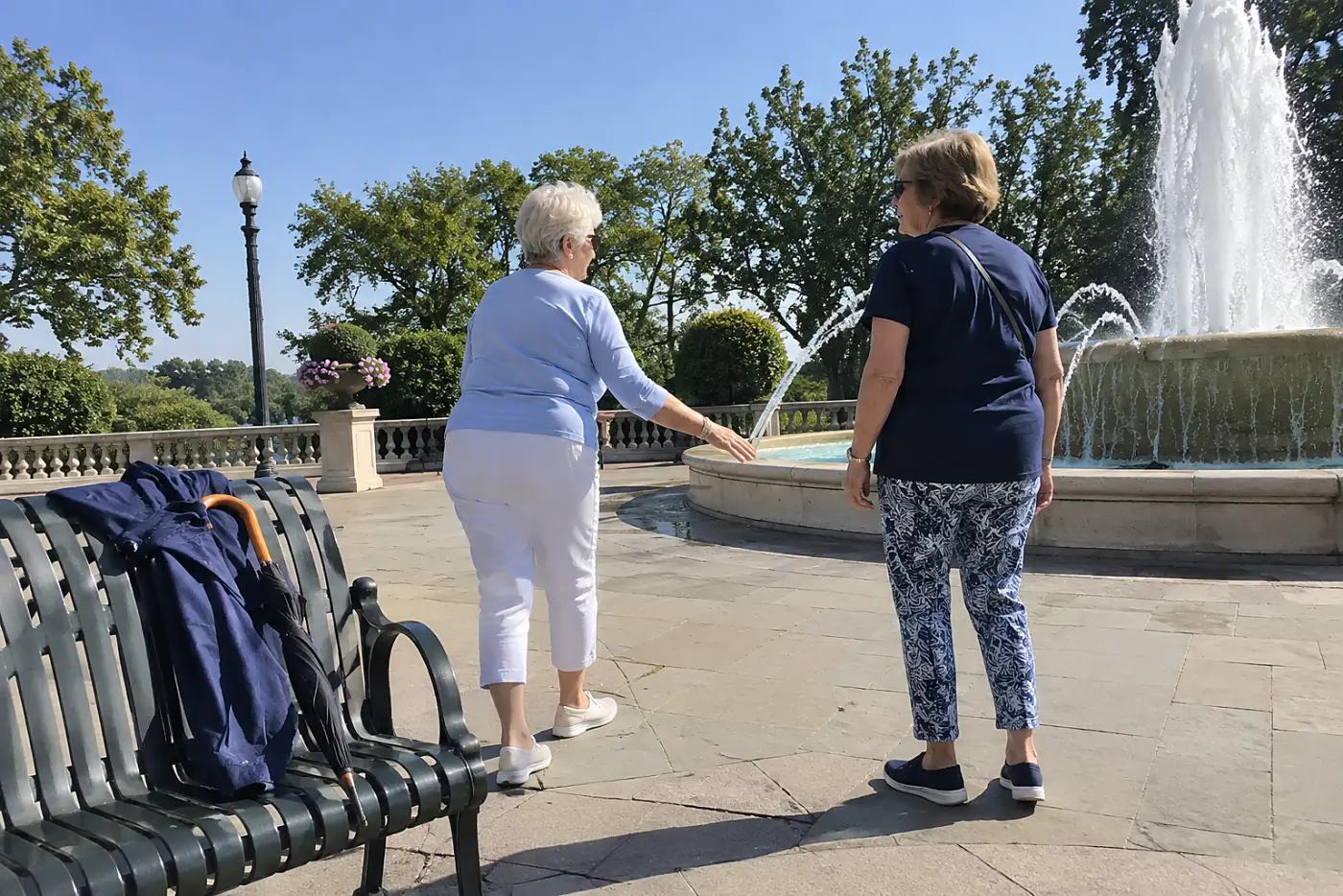 Older woman setting her phone camera timer beside a fountain.