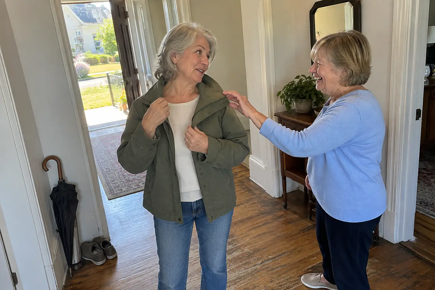 Woman showing a friend the collar of her jacket in a hallway.