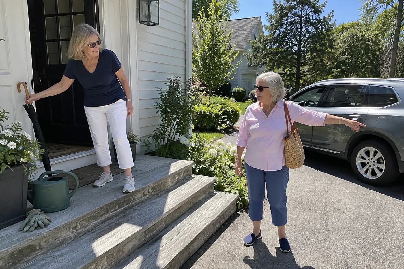 Older woman discussing a ride with a friend outside her home.