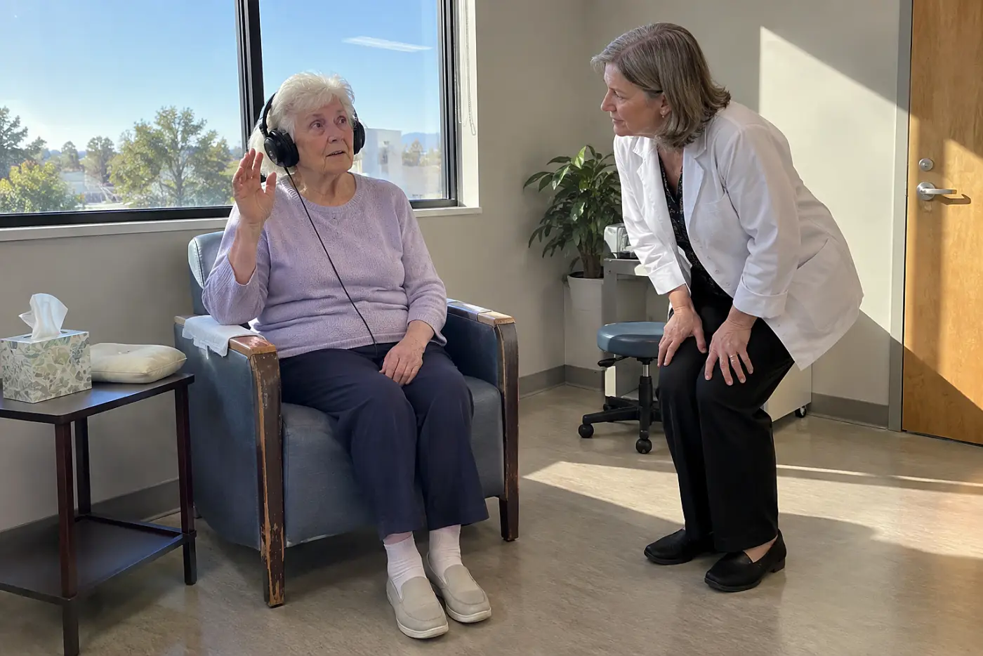 Older woman wearing headphones during a hearing test at a clinic.
