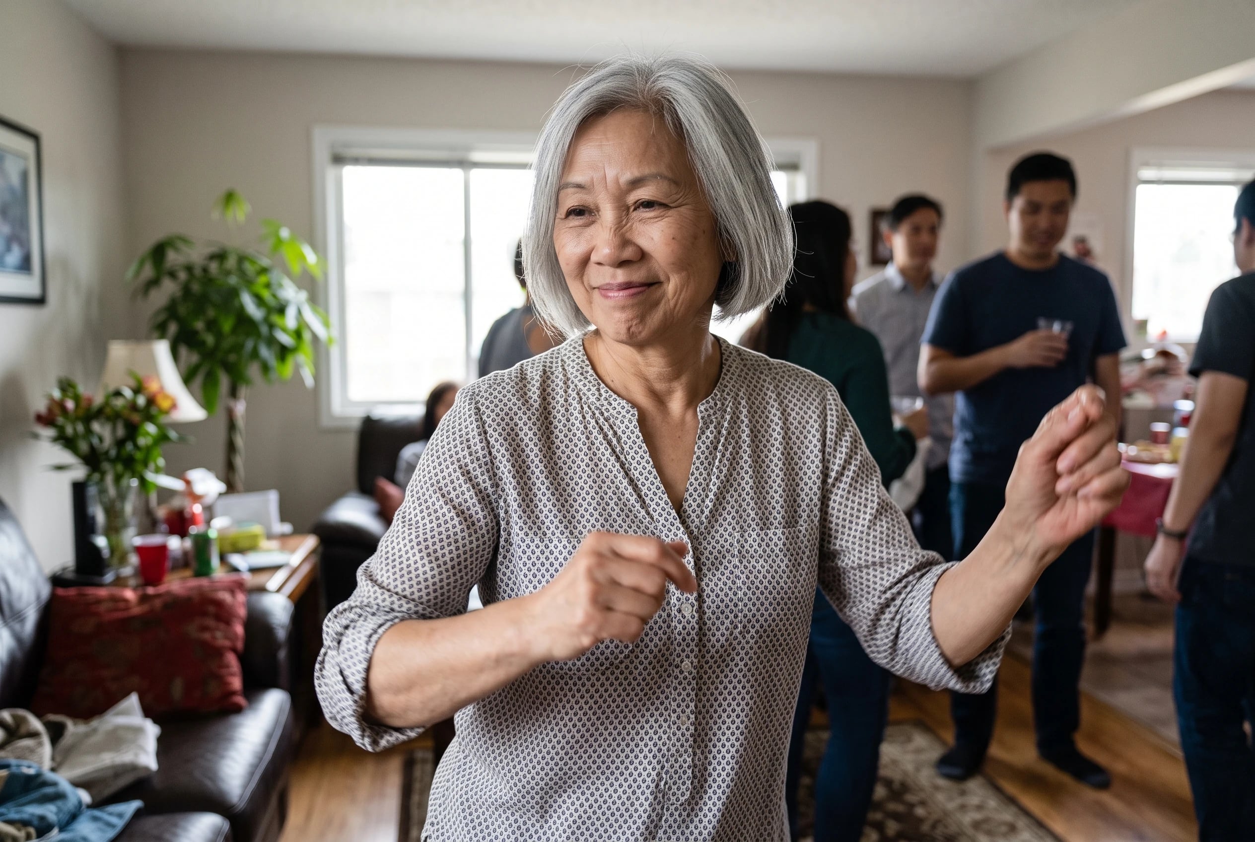 Older woman swinging her hips and hands in opposite directions at a family party.