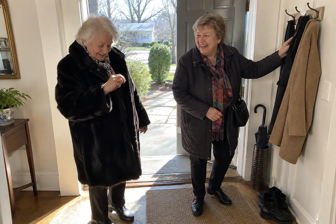 An older woman lifts a strand of fur from her black coat near her front door.