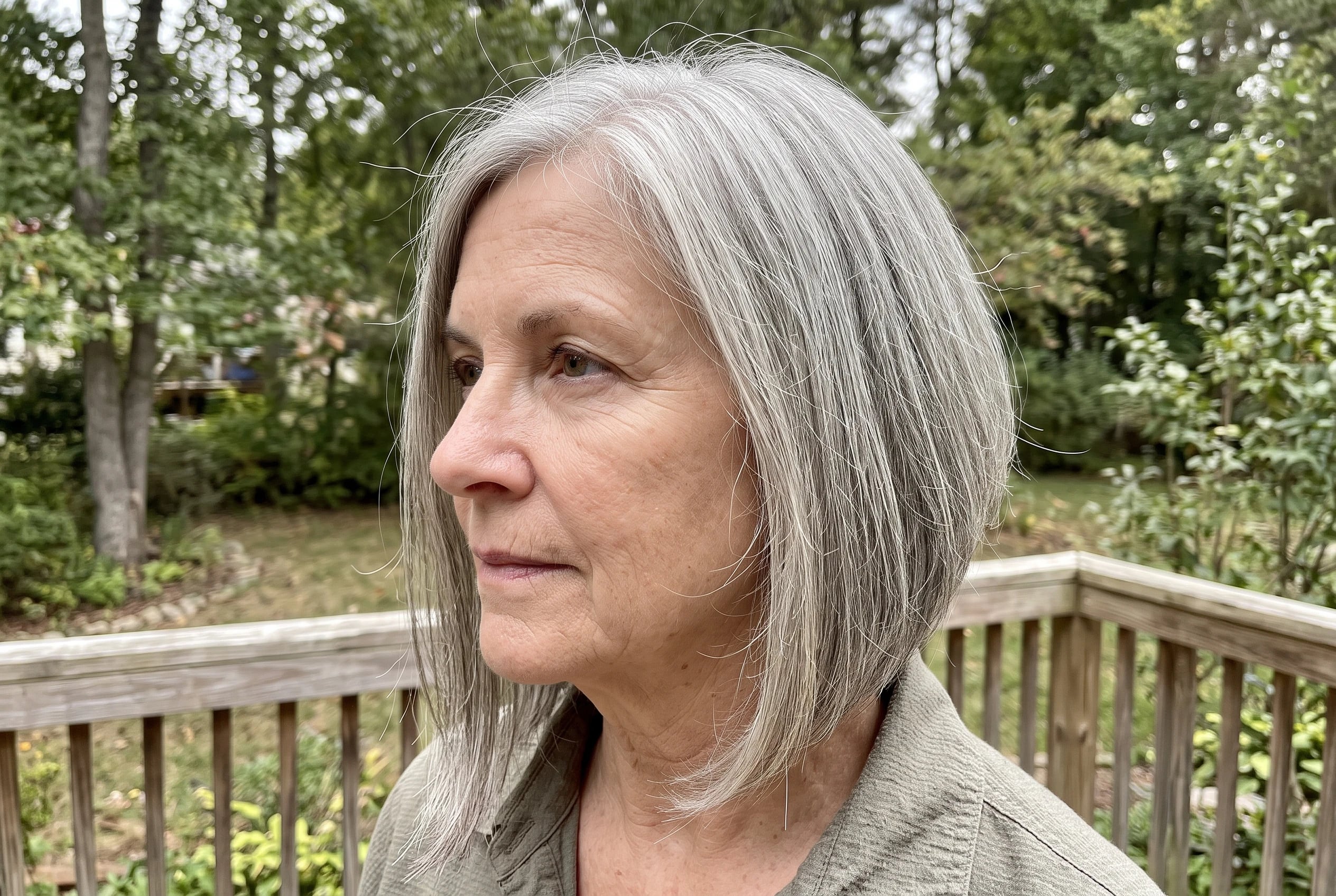A woman in her sixties with fine gray hair wears an A-line lob on a deck.