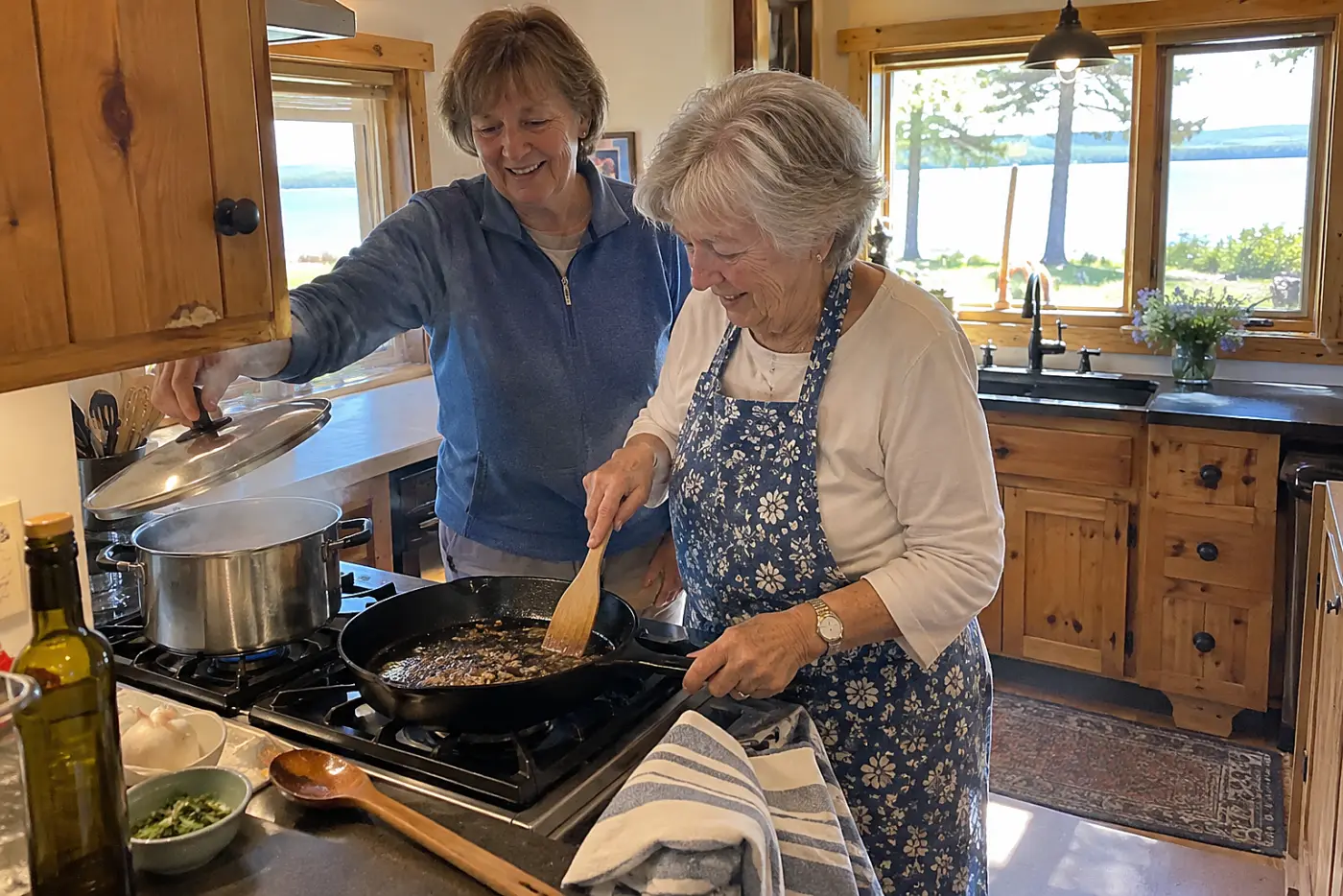A woman scrapes browned bits from a skillet in a vacation cottage kitchen.