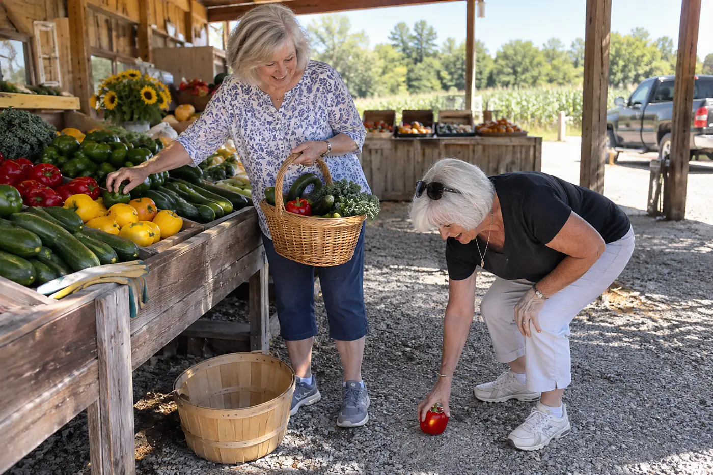 A woman chooses vegetables for teriyaki chicken at a produce stand.
