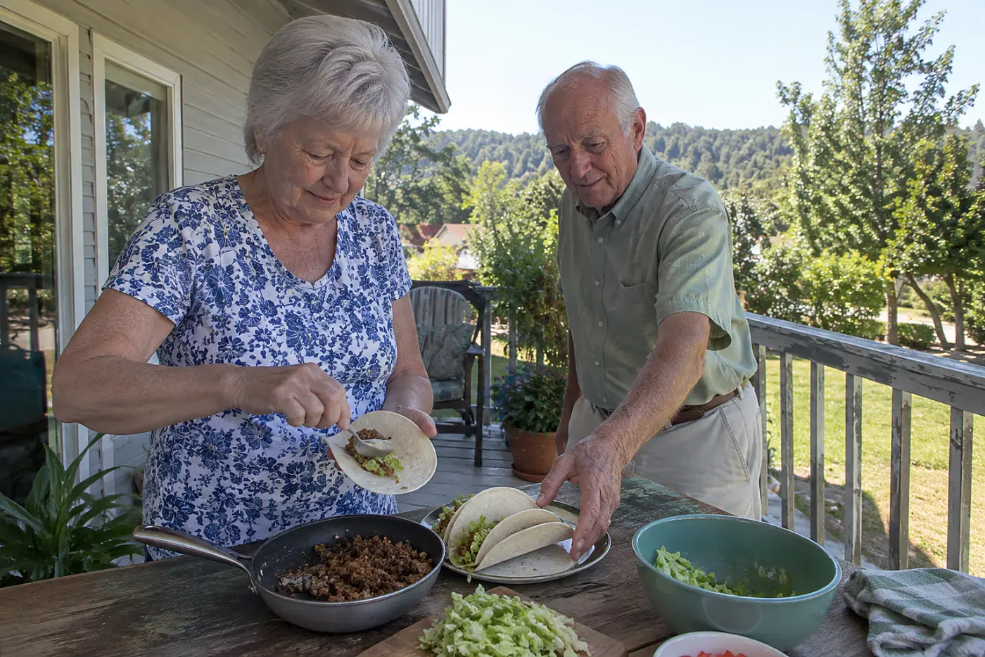 A woman fills tortillas with beef and lettuce on a back porch.